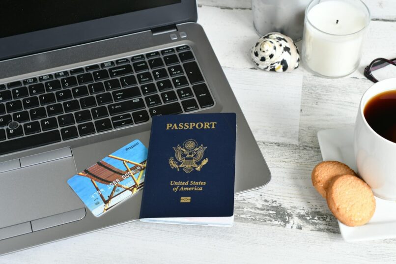 Laptop computer with passport & debit credit card - planning trip online booking reservations